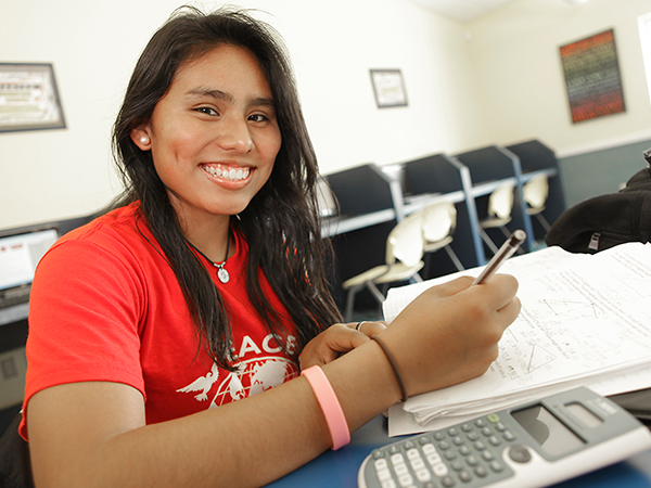 Girl smiling and working on homework